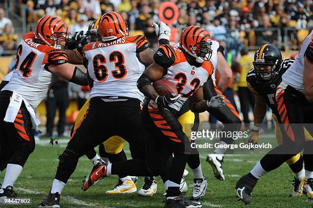 Running back Cedric Benson of the Cincinnati Bengals runs the football as offensive linemen Kyle Cook and Bobbie Williams block during a game against...