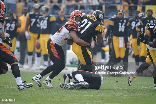 Cornerback Leon Hall of the Cincinnati Bengals tackles running back Mewelde Moore of the Pittsburgh Steelers during a game at Heinz Field on November...