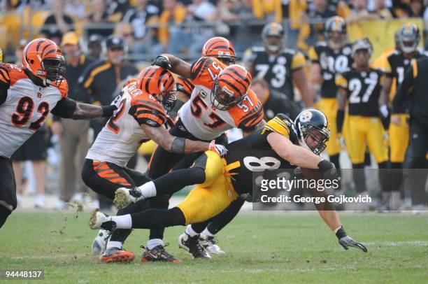 Tight end Heath Miller of the Pittsburgh Steelers is tackled by safety Chris Crocker and linebacker Dhani Jones of Cincinnati Bengals as defensive...