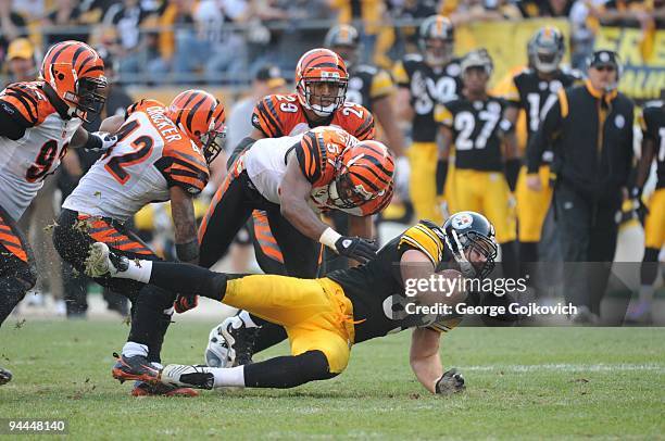 Tight end Heath Miller of the Pittsburgh Steelers is tackled by safety Chris Crocker and linebacker Dhani Jones of Cincinnati Bengals as defensive...