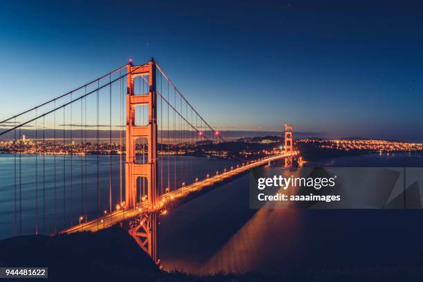 illuminated golden gate bridge over the sea,elevated view - bucht-von-san-francisco stock-fotos und bilder