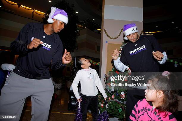 Jason Thompson and Sean May of the Sacramento Kings dance with some young fan on December 13, 2009 at Shriners Hospital for Children in Sacramento,...