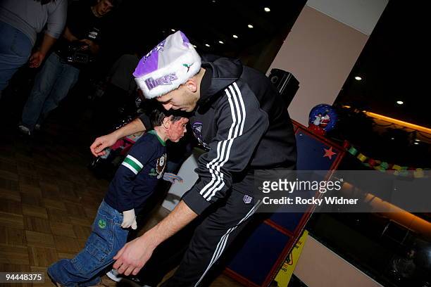 Sergio Rodriguez of the Sacramento Kings gets a hug on December 13, 2009 at Shriners Hospital for Children in Sacramento, California. NOTE TO USER:...