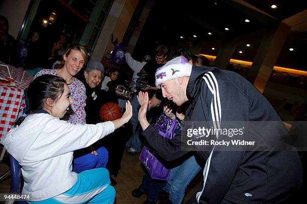 Sergio Rodriguez of the Sacramento Kings gives a high-five to this young fan on December 13, 2009 at Shriners Hospital for Children in Sacramento,...