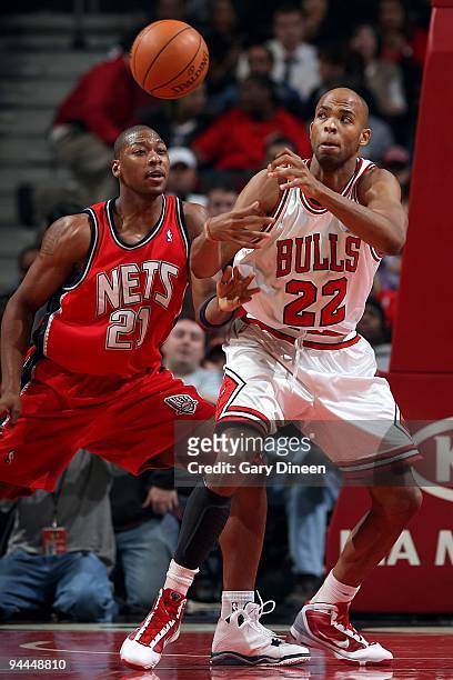 Bobby Simmons of the New Jersey Nets and Taj Gibson of the Chicago Bulls look for the loose ball during the game on December 8, 2009 at the United...
