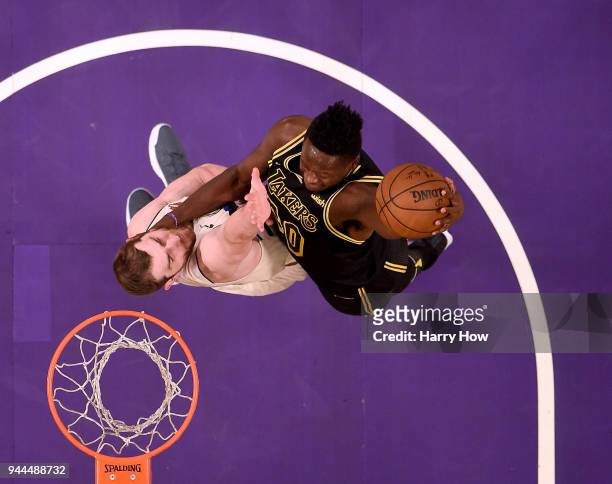 Julius Randle of the Los Angeles Lakers dunks over Tyler Zeller of the Milwaukee Bucks during the first half at Staples Center on March 30, 2018 in...