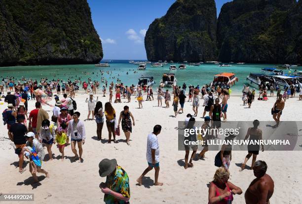 This photo taken on April 9, 2018 shows a crowd of tourists on the Maya Bay beach, on the southern Thai island of Koh Phi Phi. Across the region,...