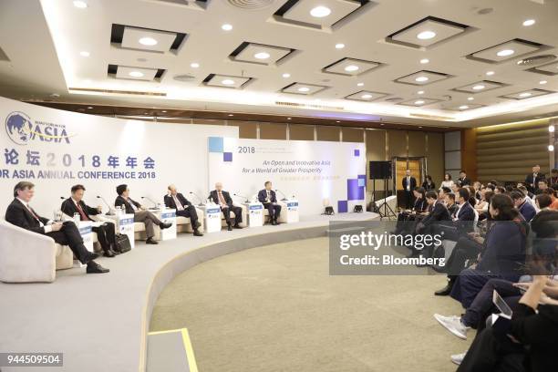 Yi Gang, governor of the People's Bank of China , seated on stage from right, Jim Stone, chief executive officer and chairman of Plymouth Rock Co.,...