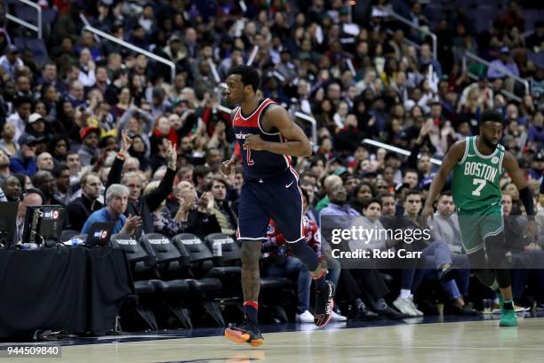 John Wall of the Washington Wizards reacts after hitting a three pointer in front of Jaylen Brown of the Boston Celtics in the second half at Capital...