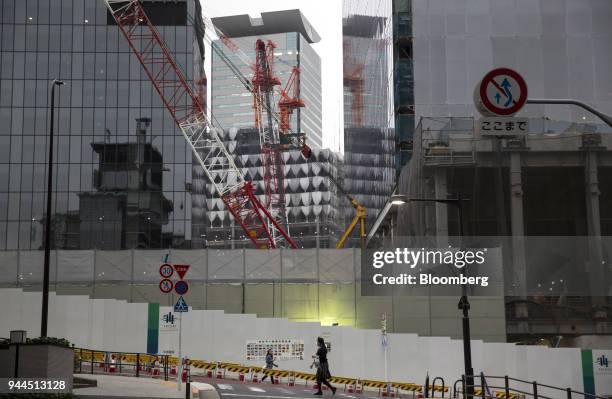 Pedestrian walks past new buildings under construction at the Hotel Okura Tokyo, operated by Hotel Okura Co., in Tokyo, Japan, on Thursday, April 5,...