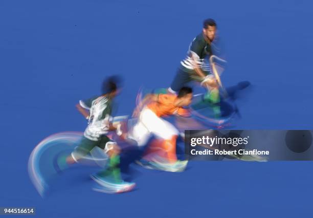 Azuan Hasan of Malaysia is chased by Ammad Shakeel Butt and Muhammad Atiq of Pakistan during the Men's Hockey match between Malaysia and Pakistan on...