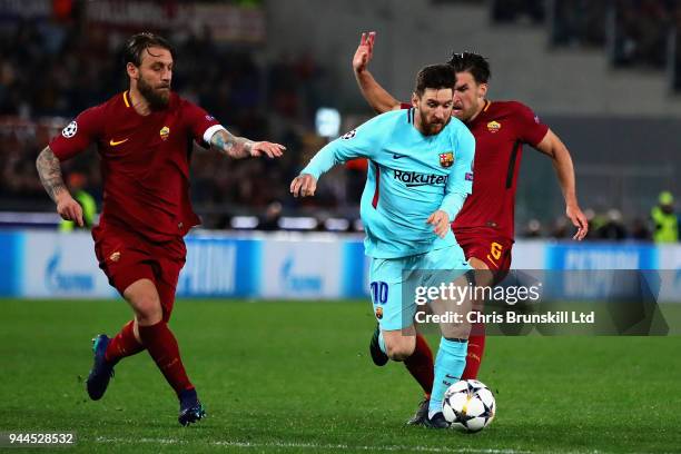 Lionel Messi of FC Barcelona is challenged by Daniele De Rossi and Kevin Strootman both of AS Roma during the UEFA Champions League Quarter Final,...