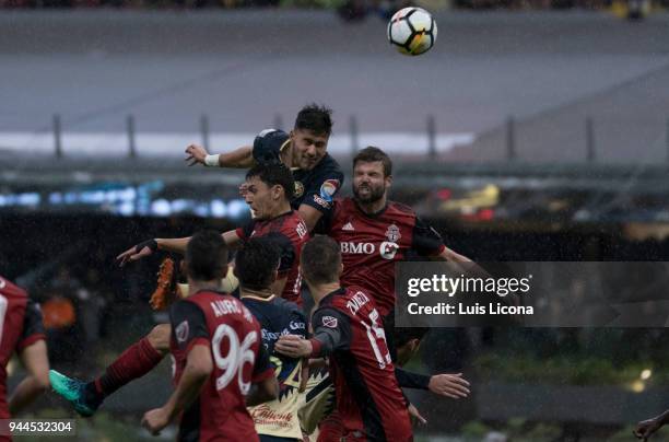 Bruno Valdez of America and Drew Moor of Toronto jump for the ball during the semifinal second leg match between America and Toronto at Azteca...