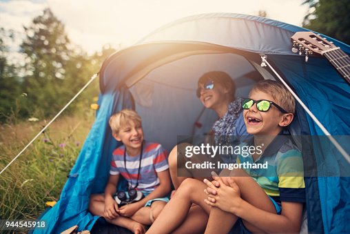 Los niños que se divierten acampar en carpa en el Prado del bosque Los niños que se divierten acampar en carpa en el Prado del bosque