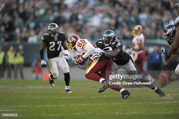 Wide receiver Santana Moss of the Washington Redskins is tackled by defensive end Chris Clemons of the Philadelphia Eagles on November 29, 2009 at...