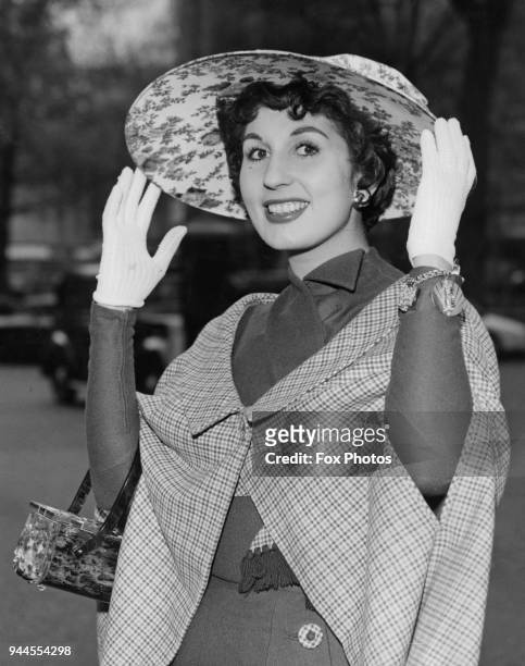 English pop singer Alma Cogan returns from a two-week visit to the United States, wearing an Easter bonnet, 20th April 1957.