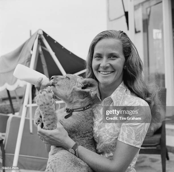 Mary Chipperfield , daughter of Jimmy Chipperfield, feeds milk to a lion cub named Marquess which is being reared by hand at the Chipperfields' home...