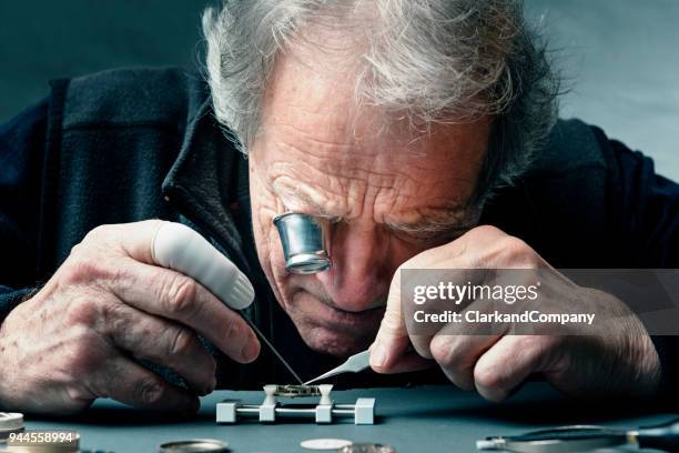 nahaufnahme eines portraits eines watchmaker bei der arbeit - old clock stock-fotos und bilder