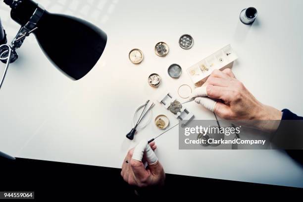 overhead view of a watchmaker at work - watch timepiece stock pictures, royalty-free photos & images