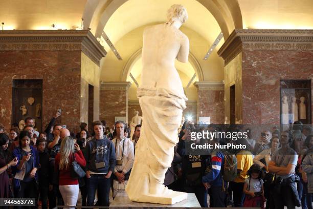 Visitors look and take pictures of the ancient Greek sculpture 'Venus de Milo' at the Louvre Museum in Paris, on April 9, 2018.