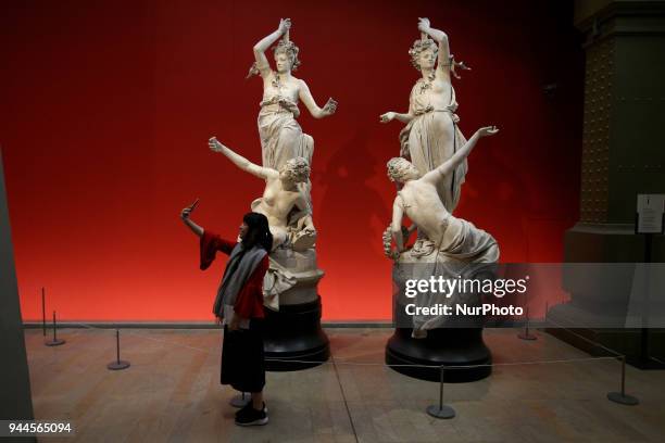 Woman takes a selfie near sculptures in the Orsay Museum - the former Gare d'Orsay train station, in Paris, on April 6, 2018.