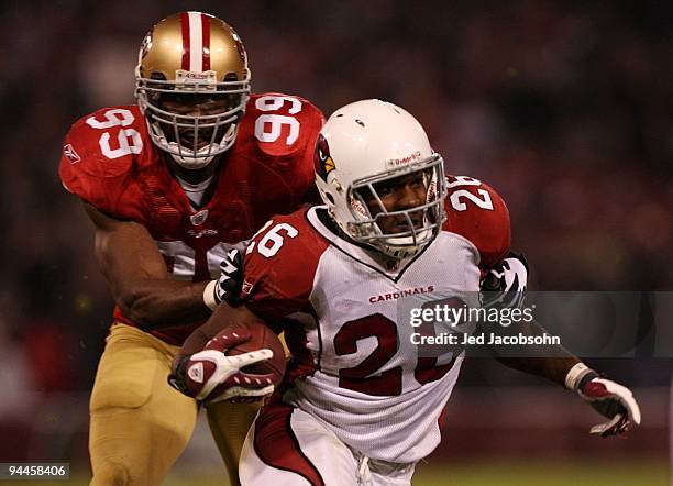 Beanie Wells of the Arizona Cardinals runs the ball as he is grabbed by Manny Lawson of the San Francisco 49ers from behind in the second half at...