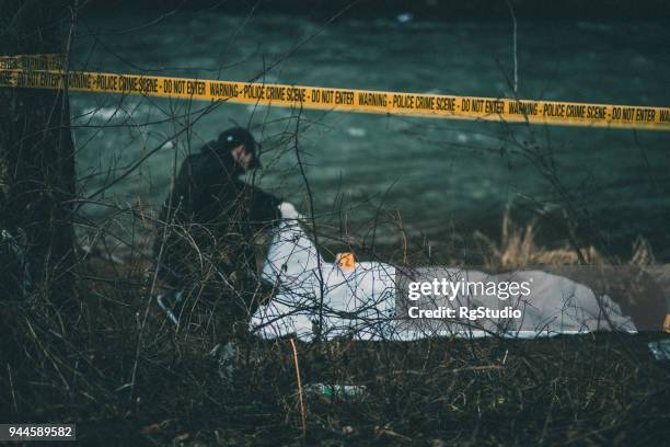 detective investigating crime scene by the river - cadaver stock pictures, royalty-free photos & images