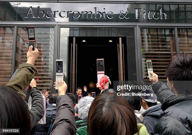 People take photographs with their mobile phones during the opening of the first Abercrombie & Fitch Co. Shop in Tokyo, Japan, on Tuesday, Dec. 15,...