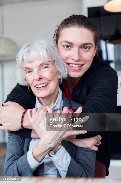 close up of a grandson embracing his loving grandmother. - all vocabulary stock pictures, royalty-free photos & images