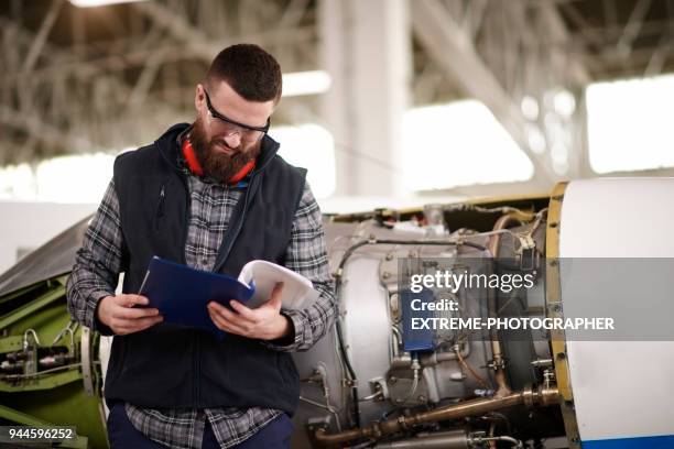 mecánico de aviones en el hangar - manual fotografías e imágenes de stock
