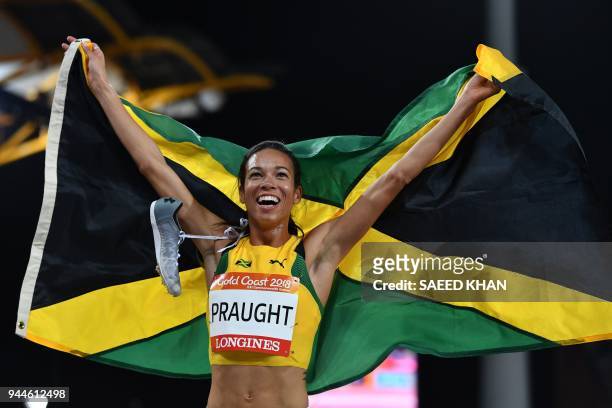 Jamaica's Aisha Praught celebrates with her flag after winning the athletics women's 3000m steeplechase final during the 2018 Gold Coast Commonwealth...