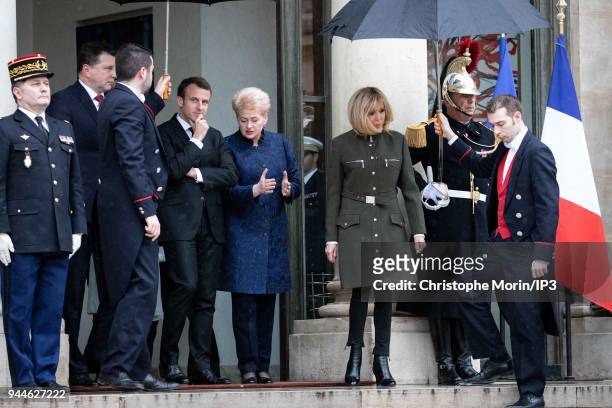 French president Emmanuel Macron and his wife Brigitte Macron leaves the Elysee palace with Lituania president Dalia Grybauskaite on April 9, 2018 in...