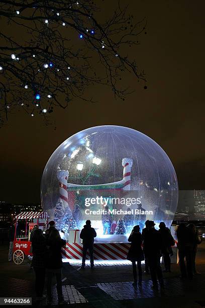 People gather for a festive high definition screening of The Grinch in a giant snow globe on the South Bank on December 14, 2009 in London, England....