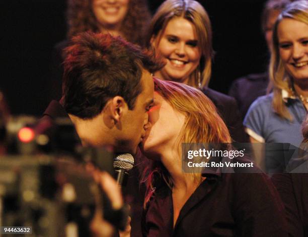 Robbie Williams performs live while kissing fans on the Dutch TV programme 'Pulse' at Hilversum Studios, Holland on December 09 2004