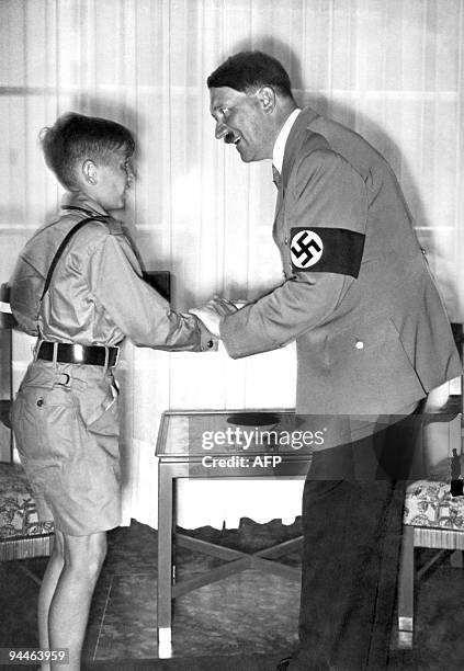 Picture dated 1936 shows German Chancellor and nazi dictator Adolf Hitler shaking hands with young Harald Quandt in his uniform of the Hitlerian...