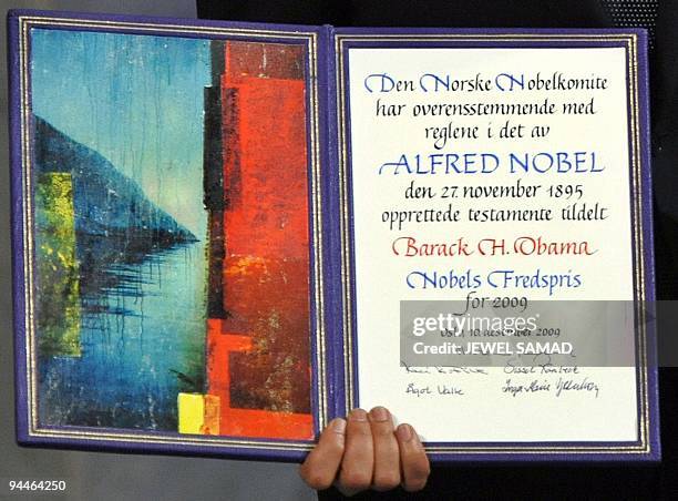 Nobel Peace Prize laureate, US President Barack Obama poses on the podium with his diploma and gold medal during the Nobel ceremony at the City Hall...