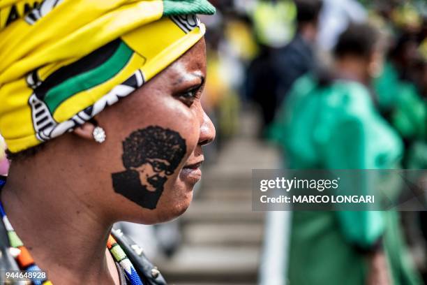 Mourner with a stamp on her cheek featuring late South African anti-apartheid campaigner Winnie Madikizela-Mandela, ex-wife of former South African...