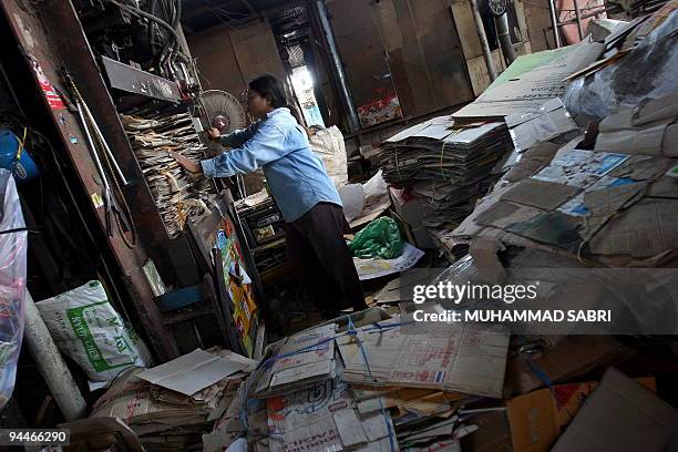 Picture taken on December 12, 2009 shows a Thai woman sorting scrap cardboard at a factory in Thailand's southern province of Yala. Eveloping nations...