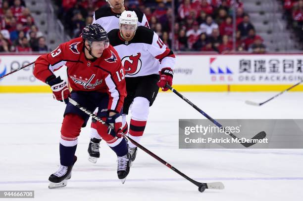 Jakub Vrana of the Washington Capitals skates with the puck against Jimmy Hayes of the New Jersey Devils in the first period at Capital One Arena on...