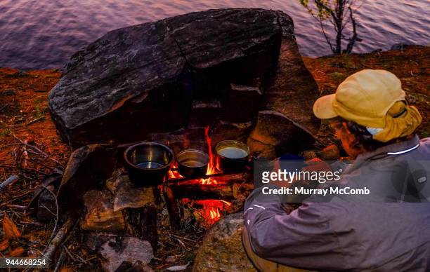 preparing campfire dinner at wilderness campsite - murray mccomb stock pictures, royalty-free photos & images