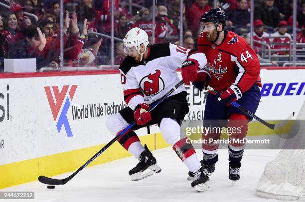 Jimmy Hayes of the New Jersey Devils and Brooks Orpik of the Washington Capitals battle for the puck in the third period at Capital One Arena on...