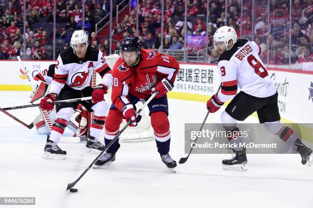 Brett Connolly of the Washington Capitals controls the puck against Will Butcher and Ben Lovejoy of the New Jersey Devils in the first period at...