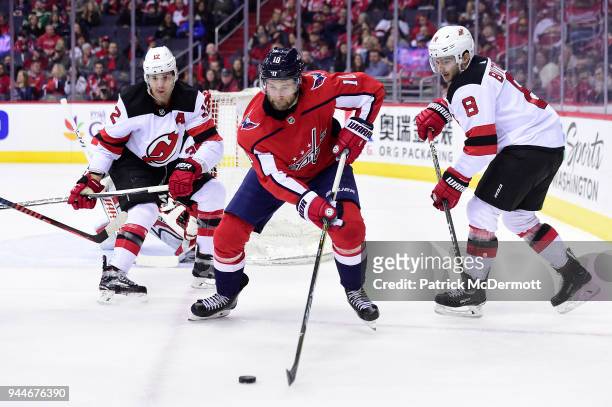 Brett Connolly of the Washington Capitals controls the puck against Will Butcher and Ben Lovejoy of the New Jersey Devils in the first period at...