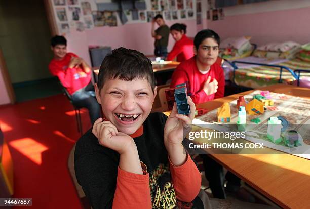 Disabled and orphaned Romanian adults play at the Babeni orphanage, southwestern Romania on November 26, 2009. Twenty years after the death of former...