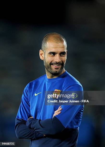 Coach Josep Guardiola of FC Barcelona smiles during a training session at the Zayed Sports City stadium on December 15, 2009 in Abu Dhabi, United...