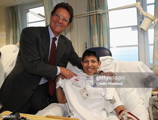England Manager Fabio Capello poses with 15 year old Zain during a Christmas visit to Great Ormond Street Hospital on December 15, 2009 in London,...