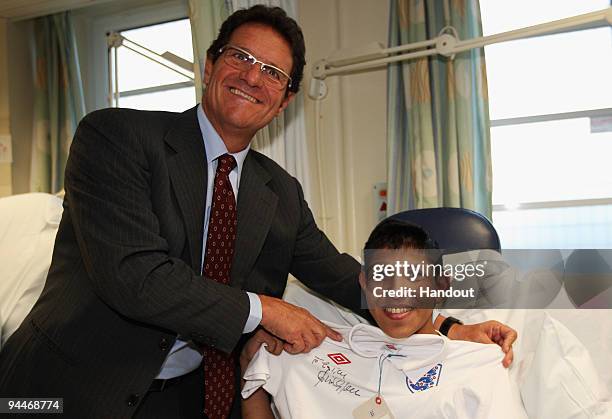 England Manager Fabio Capello poses with 15 year old Zain during a Christmas visit to Great Ormond Street Hospital on December 15, 2009 in London,...