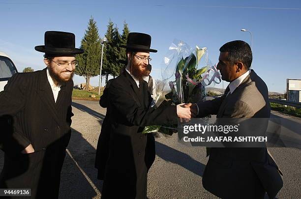 Members of the anti-Zionist religious Jewish community Naturei Karta, give on December 15, 2009 a bouquet of flowers to the Palestinian President of...