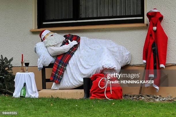 Doll dressed as Santa Claus lying in a bed and with a glass of wine next to him, has been set up in a private garden on December 15, 2009 in Bad...