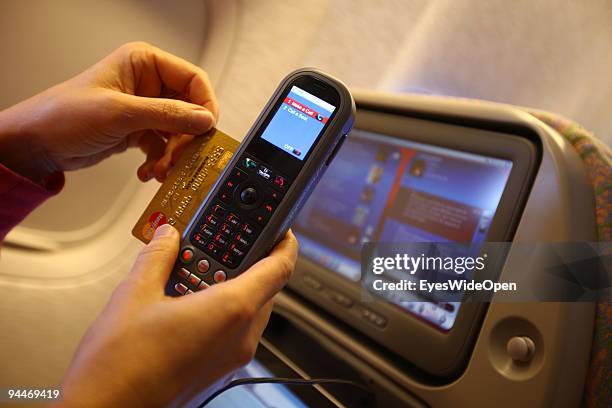 Woman is working an makes a telephone call, paid by credit card on board of a Emirates Airline passenger jet on December 08, 2009 in Trivandrum,...